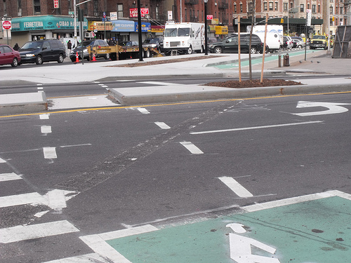 Cyclists can wait to cross Amsterdam Avenue in a bike box, before they enter a parking protected contra-flow lane on the other side. A pedestrian refuge island also shortens crossing distances and calms traffic. Photo: BicyclesOnly via Flickr.