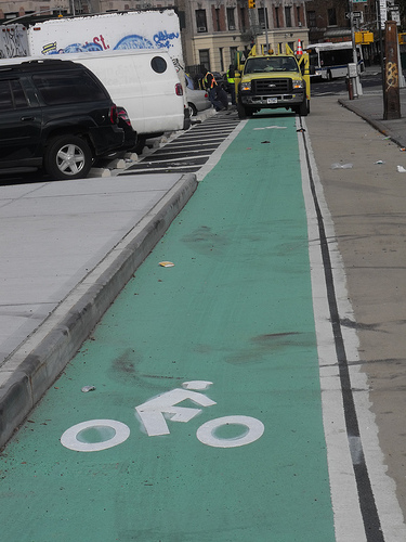DOT workers installing the one block-long contraflow bike lane on St. Nicholas. Photo: BicyclesOnly via Flickr.