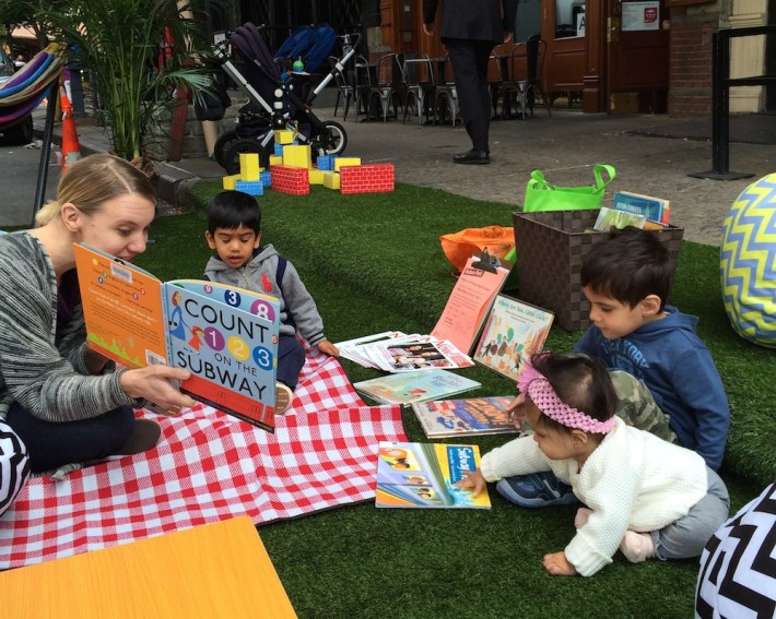 Kristy Raffensberger of the New York Public Library reads to children in a Park(ing) Day space in Tribeca. Photo: HR&A Advisors