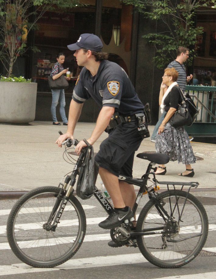 An NYPD officer rides without a bike helmet. Photo: Liz Patek/Flickr