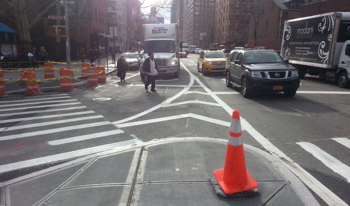 Most of the intersection of Houston Street and Sixth Avenue used to be wide-open asphalt. DOT is now putting the finishing touches on expanded pedestrian space at this deadly crossing. Photo: Stephen Miller