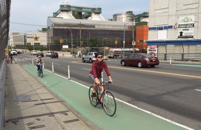 The plastic bollards continue even when the bike lane buffer disappears. Photo: Clarence Eckerson Jr.