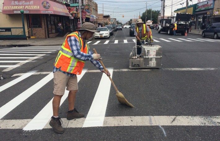 Crews stripe crosswalks on Pitkin Avenue. The bike lane is up next. Photo: Stephen Miller