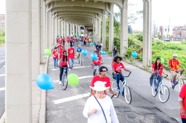 The Rockaway Bike Parade beneath the elevated train on Rockaway Freeway earlier this month. Photo: Rockaway Waterfront Alliance