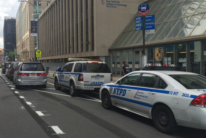 Double-whammy: these caps are blocking a bus stop and the bike lane. Photo: Brandon Chamberlin