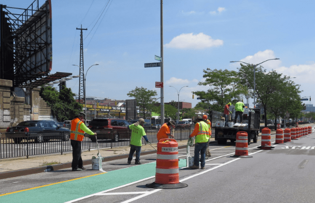 DOT crews installing the new protected bike lane earlier this month at Kneeland Street. Photo: DOT