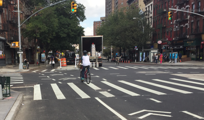 Cyclists entering the First Avenue protected bike lane at East First Street. Photo: David Meyer