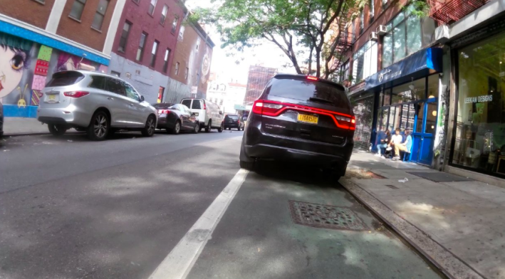 Idling cars pulling in and out of bike lanes are a regular threat to the safety of people riding bikes on city streets. Image: @bikelaneblitz