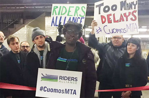 Riders Alliance member Tolani Adeboye speaks at yesterday's rally for better subway service. Photo: David Meyer