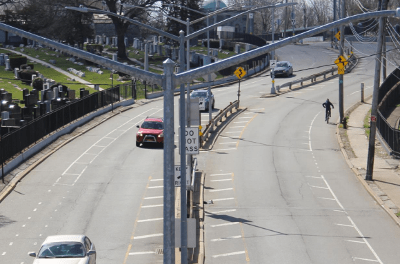 Cypress Hills Street, pictured, could provide safe access from Glendale, Queens to cemeteries and parkland, but its existing design feels more like a highway. Photo: DOT