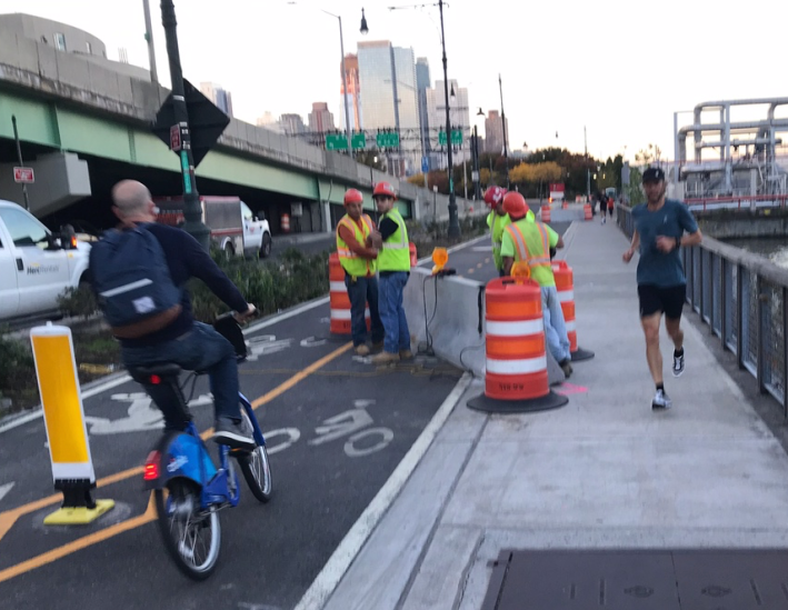 Near 59th Street, a cyclist heads into the oncoming lane to steer around a state DOT jersey barrier. Photo: Mark Gorton