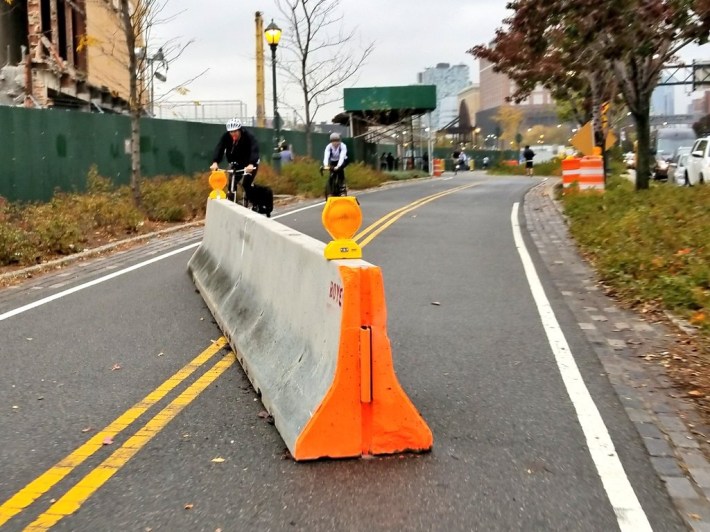 Bulky jersey barriers remain strewn across the Hudson River Greenway at dangerous angles, three days after state DOT said they would be straightened out. Photo copyright Shmuli Evers, used with permission.