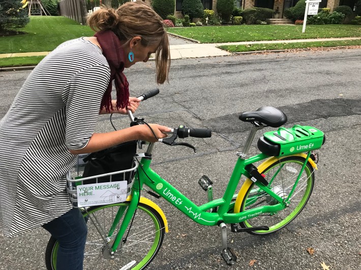 A Lime customer adjusts the handlebars of a misaligned bike. Photo: Gersh Kuntzman
