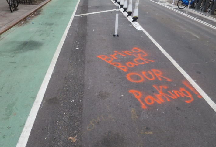 This graffiti appeared on 13th Street near Avenue A on Thursday. It is a reference to parking spaces that were removed to provide more safety for cyclists. Photo: Chelsea Yamada.