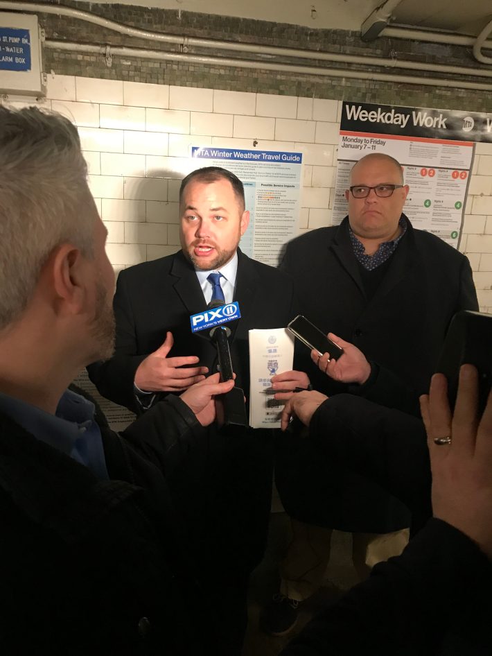Speaker Corey Johnson talks to reporters while Council Member Justin Brannan looks on (for the record, Brannan was not in a bad mood, despite the timing of our shutter).