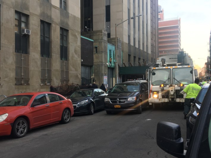 Illegally parked placarded cars block other city workers from doing their jobs and endanger the rest of us, as this typical Lower Manhattan scene shows. Photo: Ben Verde
