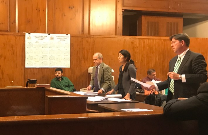 Lawyers in the Morris Park Avenue case include (from right) John Parker, representing several Morris Park business owners, and city lawyers Yangbi Jang and Mark Mushchenheim. Concerned citizen Michael Kaess (in green) looks on.