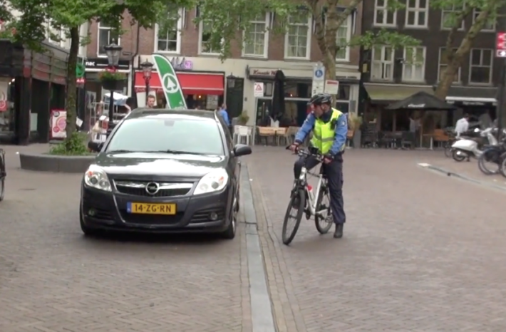 Yes, this is a Dutch cop telling a driver to get his car out of the pedestrianized core.