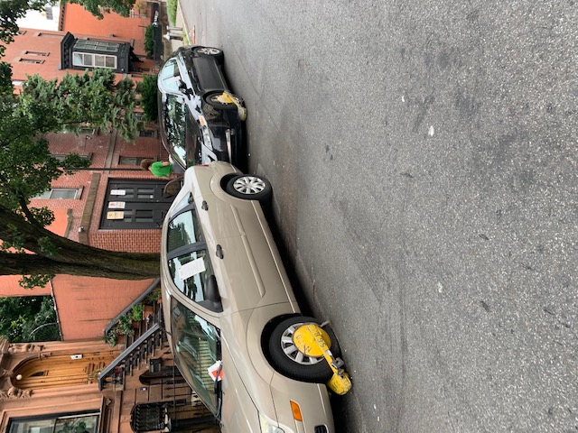 The city booted some cars parked in the new no-parking area on Greene Avenue as part of a new citywide residential loading zone pilot program.