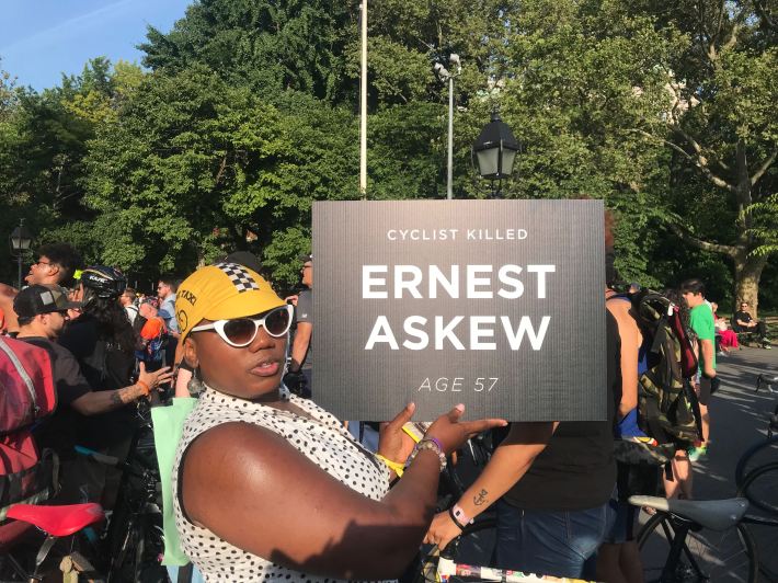 A woman holds up a sign for Ernest Askew, a cyclist killed recently on the streets of Brooklyn.