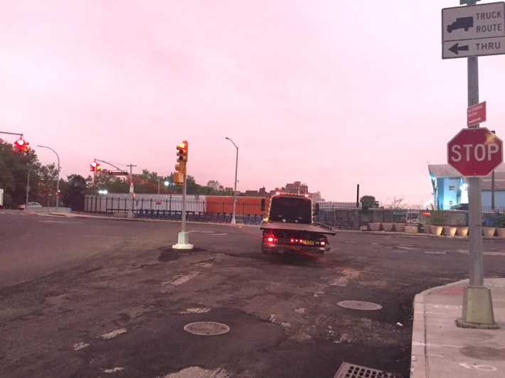 This truck is blowing through a red light in order to make a left turn from the right lane at Furman Street and Atlantic Avenue in Brooklyn. Cyclist Alan Mukamal made this turn from the right of the signal pole on a green signal. Photo: Alan Mukamal
