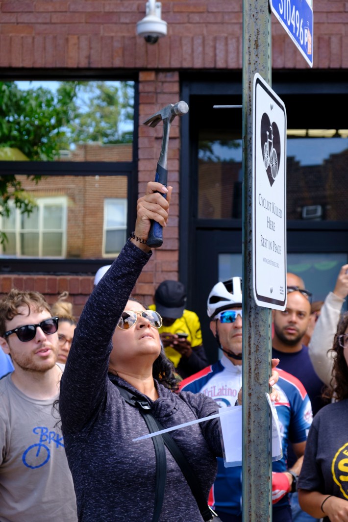 Alzorriz's partner Irene Hanna helped hang the ghost bike sign. Photo: Vladimir Vince