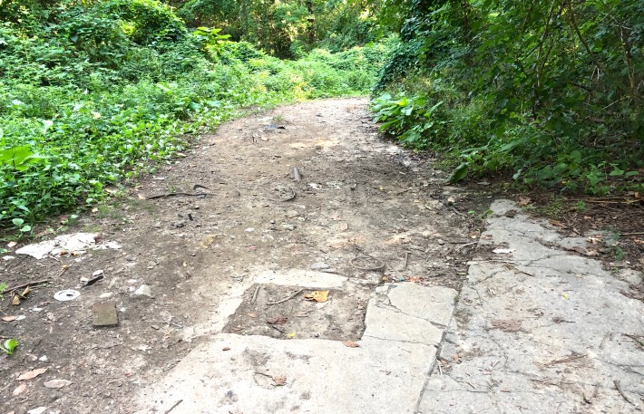 Chewed up pavement makes for tough going for cyclists further along the level path. Photo: Daniel O’Neil