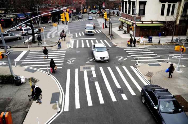 Curb extensions and neckdowns, like those shown in this NYC DOT picture, make roadways safer. Yet DOT says it needs a maintenance partner before it can build them.