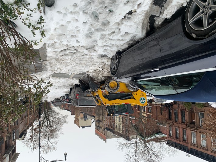 A DSNY machine tries to clean out a bike lane in Park Slope — four days after the end of this winter's first storm. Photo: Gersh Kuntzman