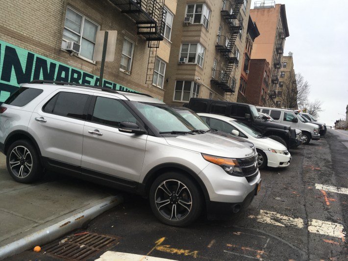 The sidewalk of the north side of 183rd Street, across the street from the 34th Precinct on Broadway, covered with police officers' vehicles, mostly private ones. Photo: Eve Kessler