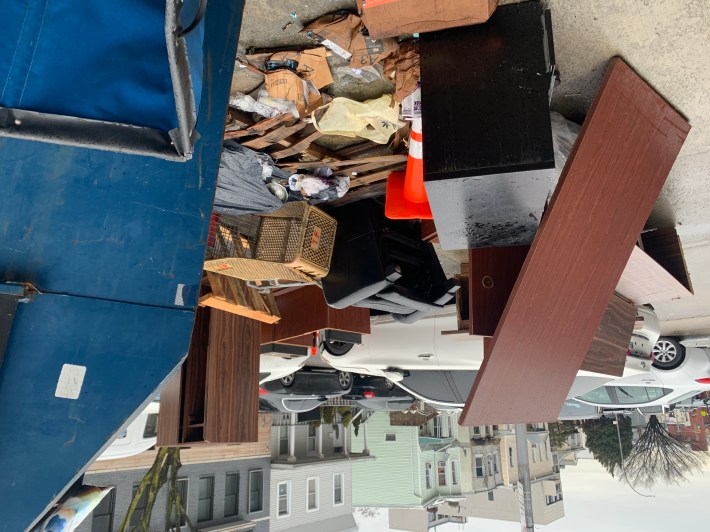 Also, there are two ugly Dumpsters with garbage and office furniture spilling out of them.