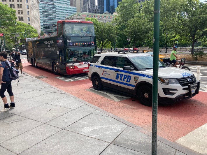 Despite the clear "Only Bus" signs, an NYPD car used the lane as a regular one, impeding the tour bus behind.