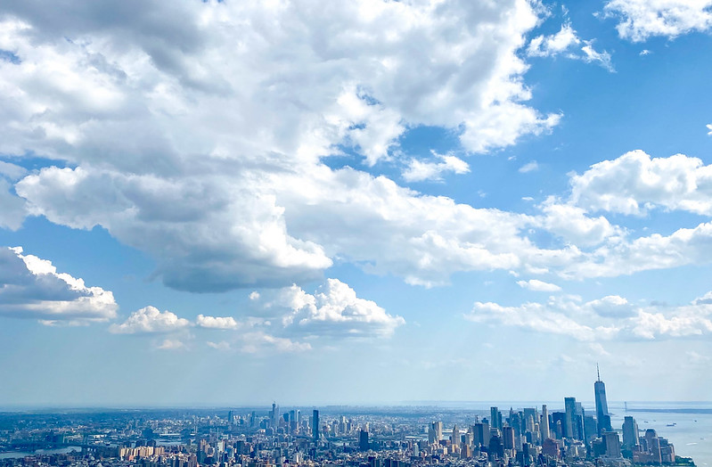 A photo of the Manhattan skyline with lots of fluffy clouds and blue sky.