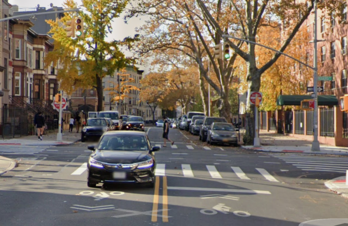 St. John’s Place at Rogers Avenue in Brooklyn. The street goes from 2-way to 1-way, and cyclists are given no information as to what to do. How many simply continue straight? Photo: Google Maps.