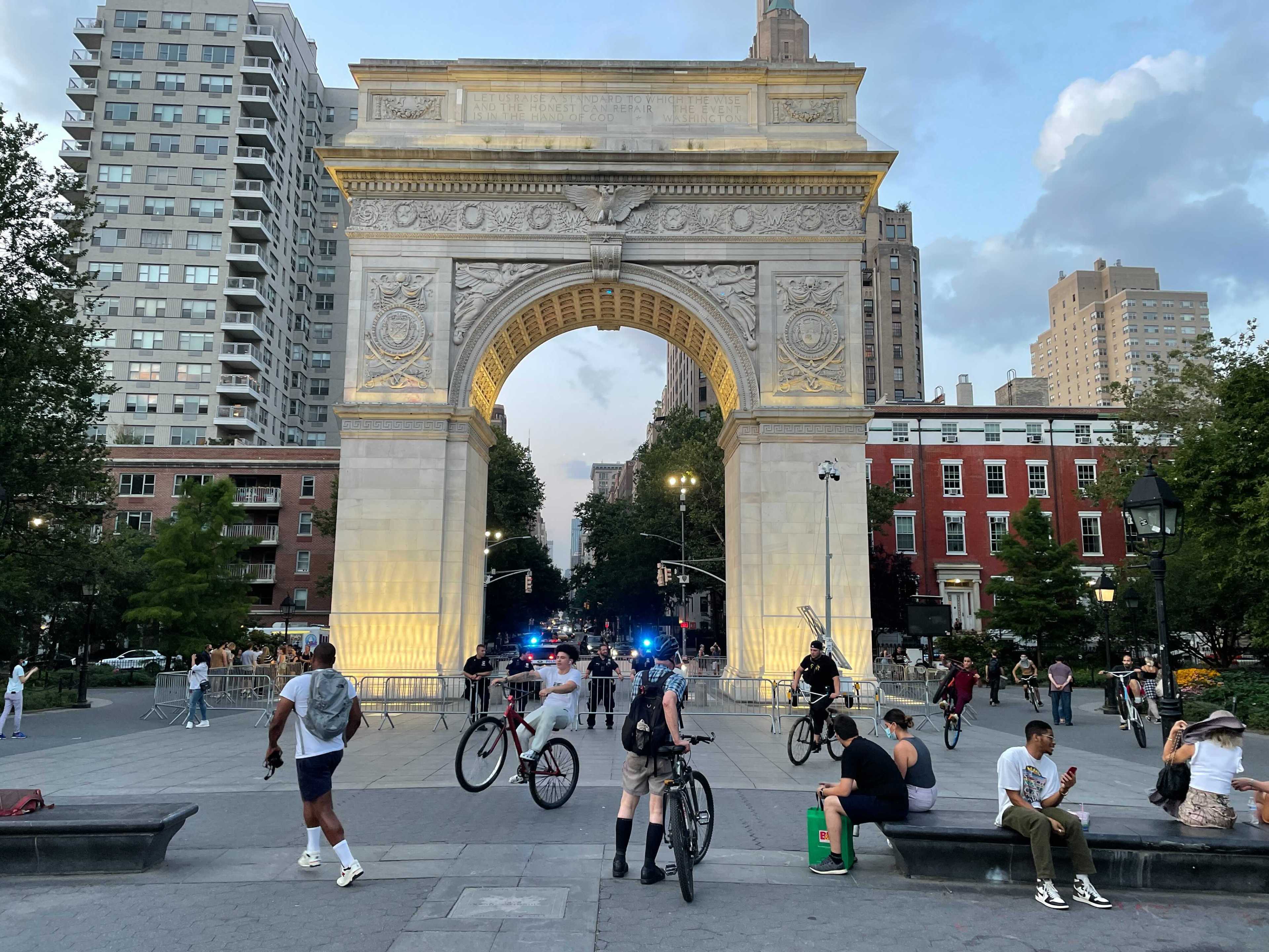 Washington Square Park on Wednesday night, looking at the arch as people mill around it and the cops watch over it.