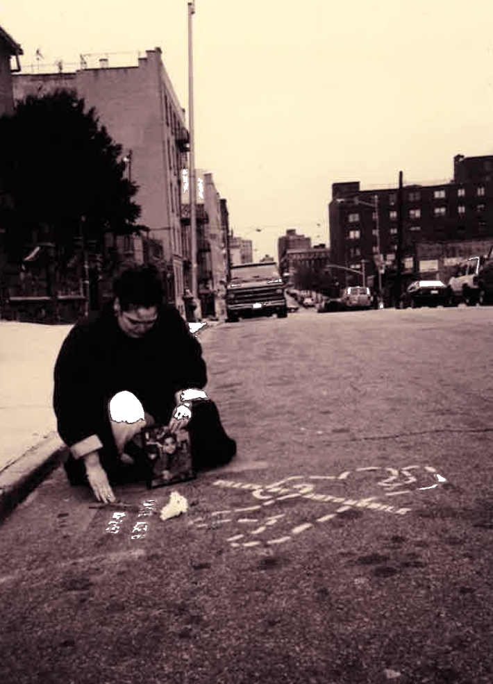 Evelyn Cancel kneeling in roadway. Photo: Damon Brandt