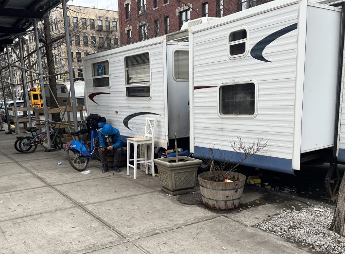 A man sits in front of the derelict RV on West 178th Street. He told Streetsblog he did not live there. Photo: Eve Kessler