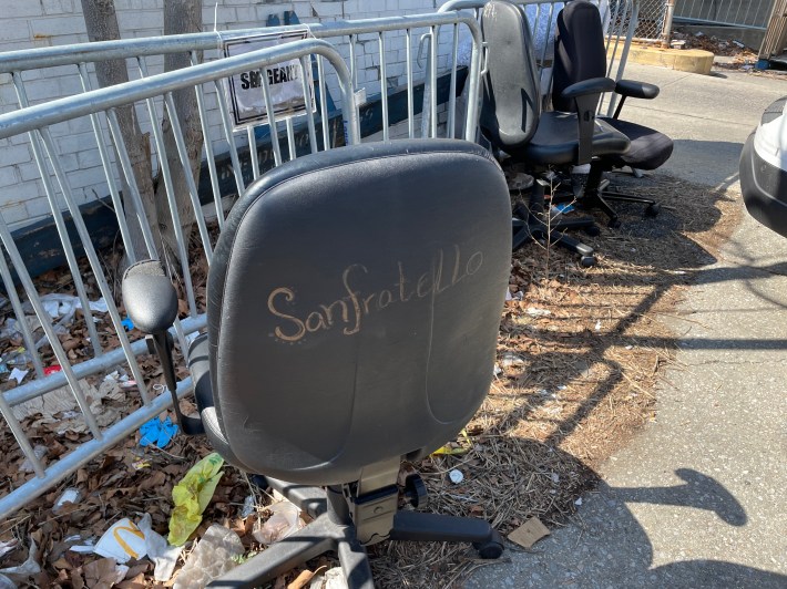 A personalized tossed out chair on the sidewalk outside the 69th Precinct.