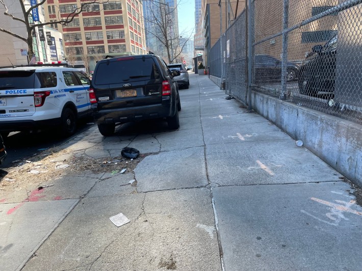 Someone parked on the sidewalk next to one of the 84th Precinct's two parking lots.