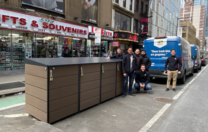 A crew from CITIBIN poses next to the Times Square Alliance trash enclosure at W. 43rd Street and Eighth Avenue. CITIBIN manufactured and installed the enclosure. Photo: CITIBIN