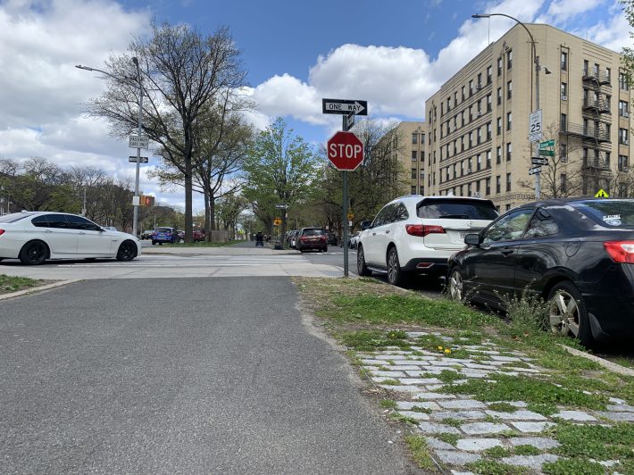 The abandoned car (black) and the illegally parked police officer's car (white) in a "No Standing" zone make it difficult for turning drivers to see other cars. Photo: Gersh Kuntzman