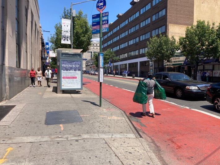 One woman going to wait at the bus stop with two big bags. Photo: Julianne