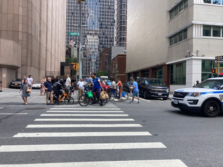 Passerby, many of them delivery workers, at the scene of a scooter crash in Tribeca on Wednesday. Photo: Julianne Cuba