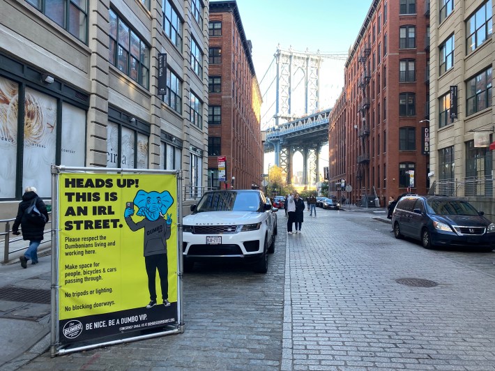 A sign by the local DUMBO business improvement district reminds visitors that Washington Street is an "IRL street," asking them to make space for others passing through. Photo: Kevin Duggan