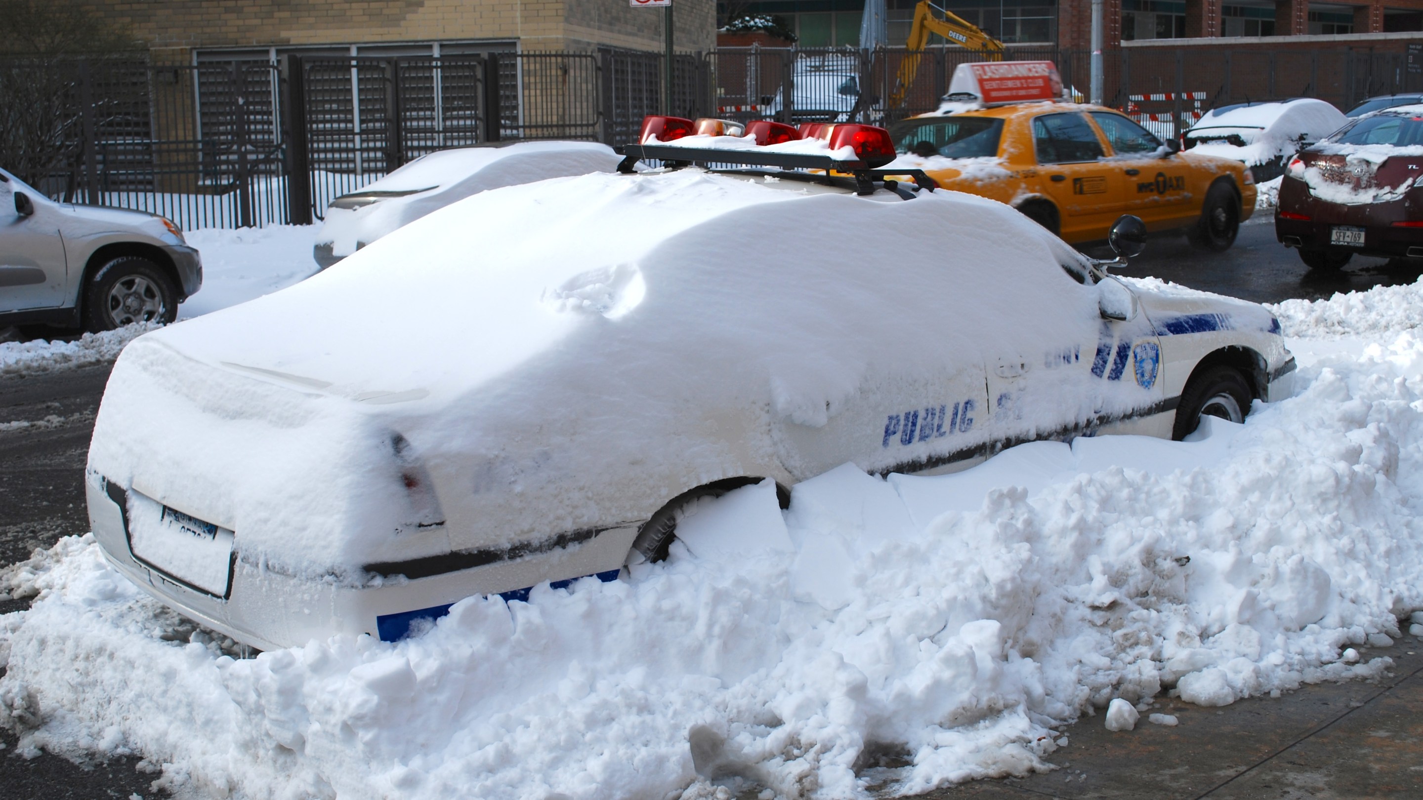 An NYPD squad car buried in snow.