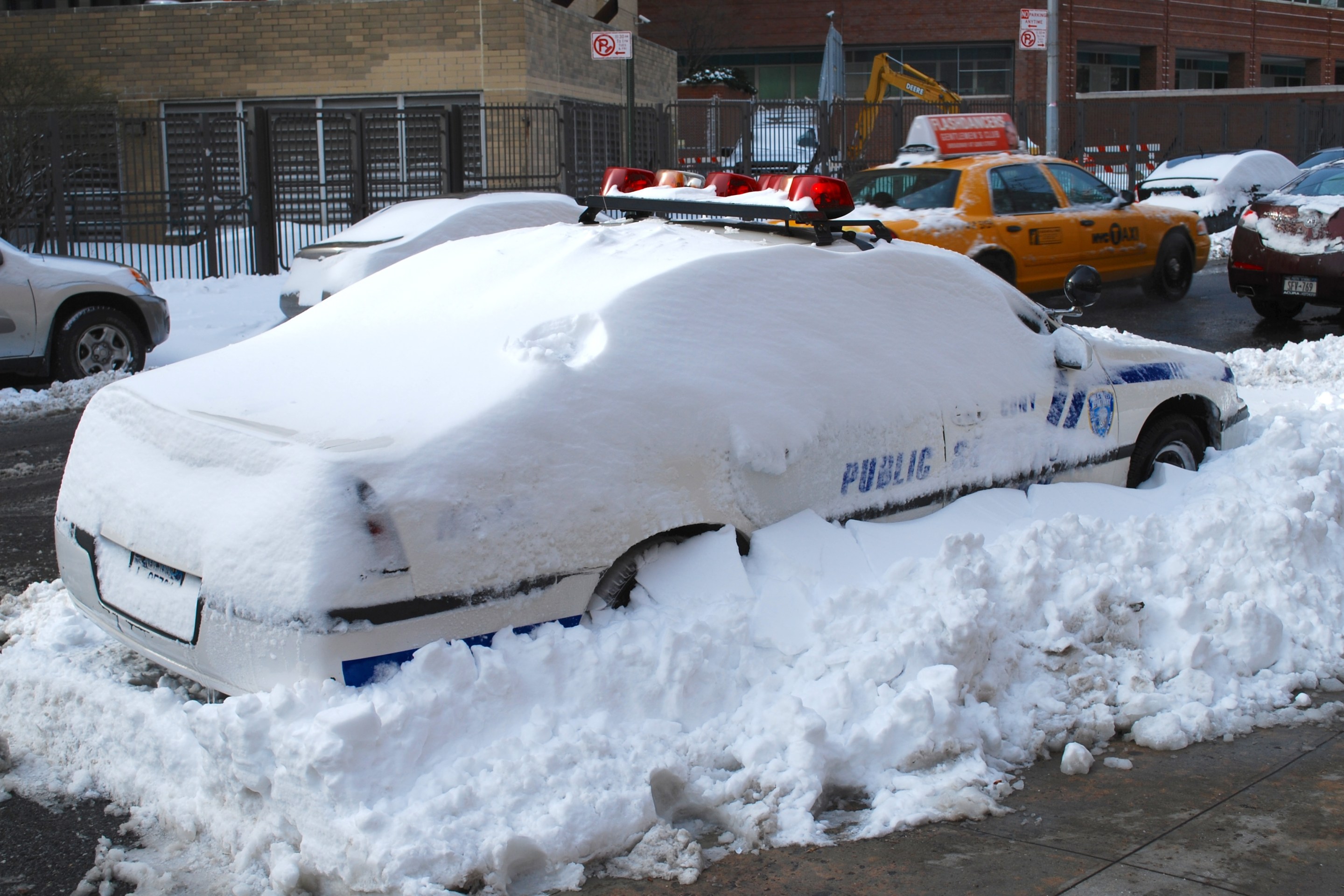 An NYPD squad car buried in snow.