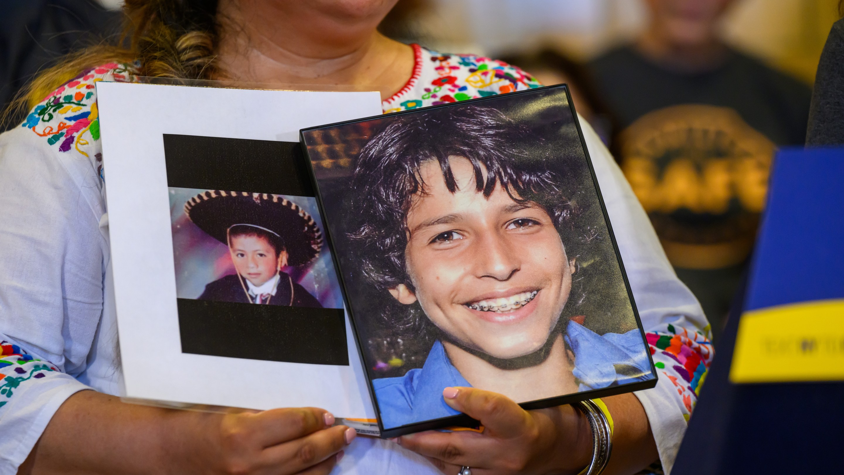 A woman holds two photos of Sammy Cohen Eckstein, whom a driver killed on Prospect Park West in 2013.