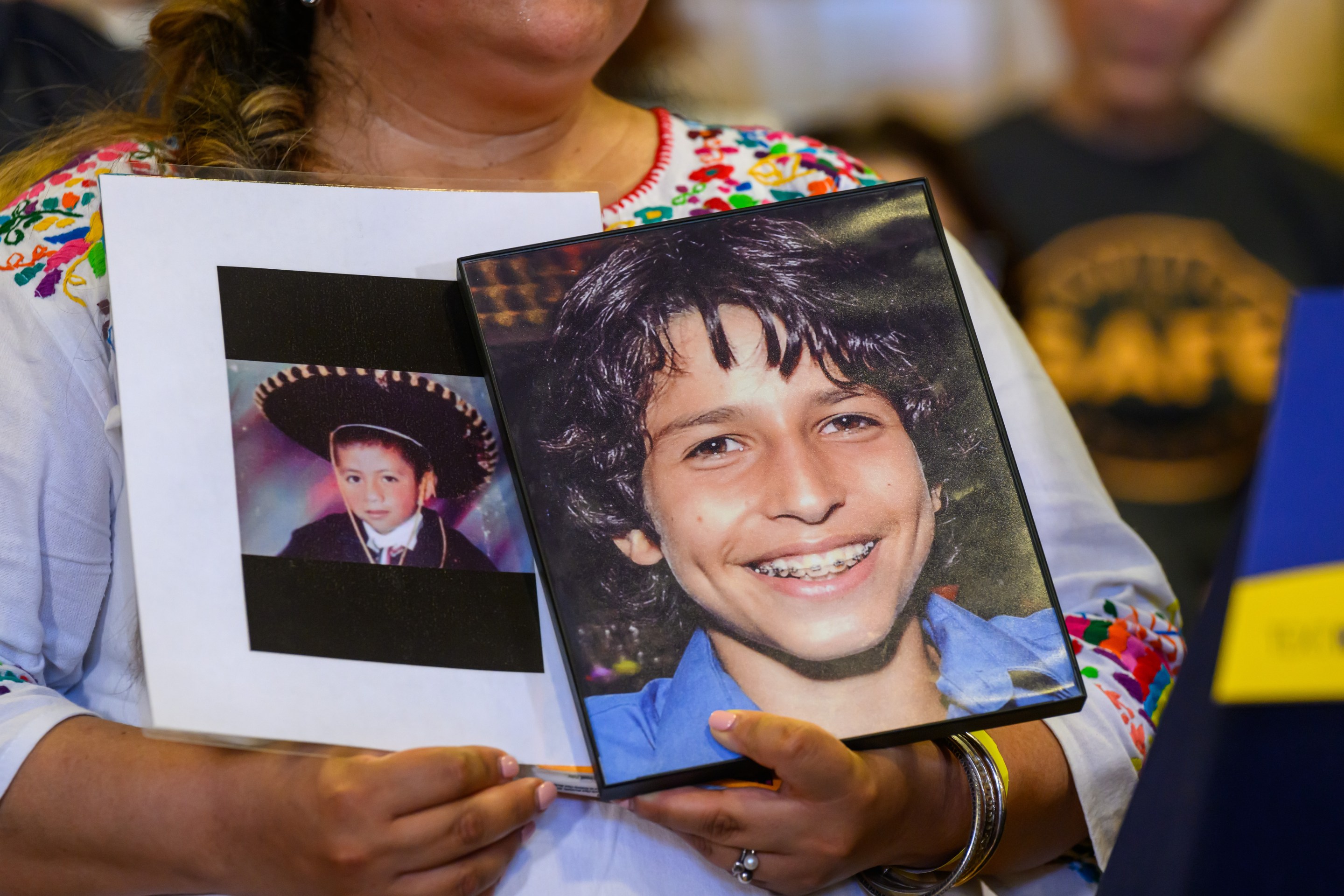 A woman holds two photos of Sammy Cohen Eckstein, whom a driver killed on Prospect Park West in 2013.