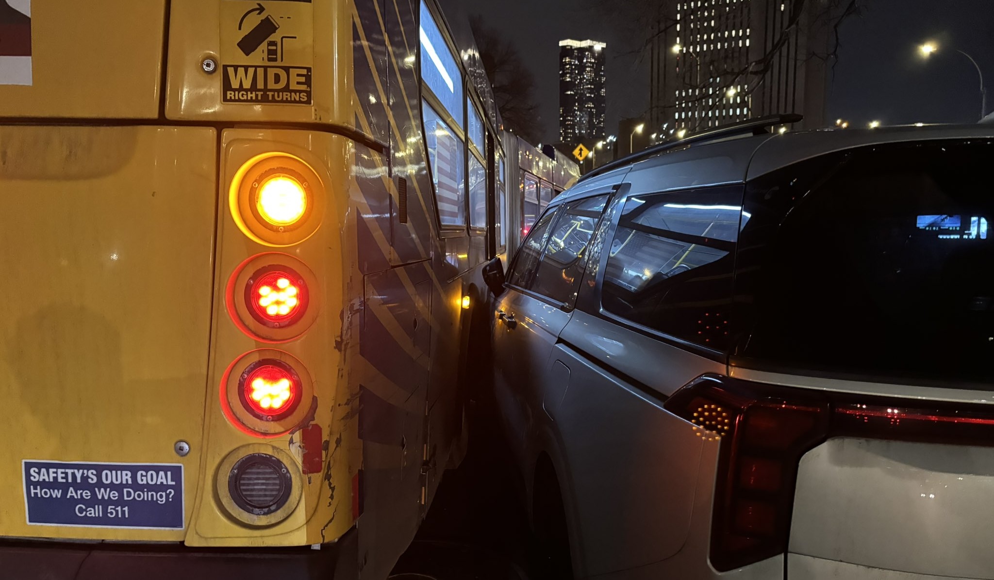 An MTA bus sideswipes an illegally parked car with an NYPD placard in lower Manhattan.